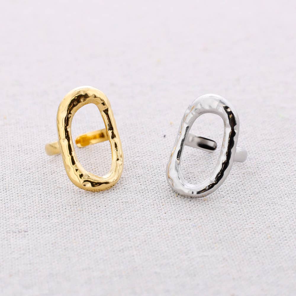 Gold and silver oval hoop ring on a light gray background