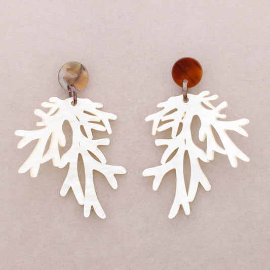White coral-like earrings on a beige background