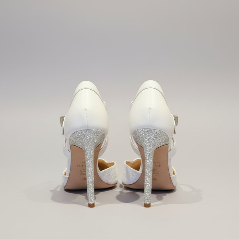 Pair of white high-heeled shoes  on a wooden surface.