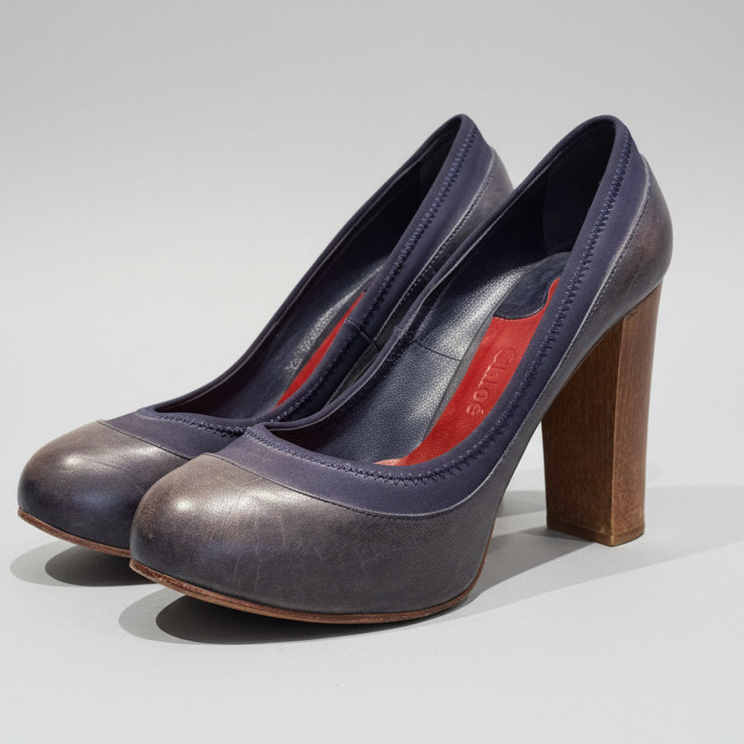 Pair of high-heeled shoes on a wooden surface with a white background