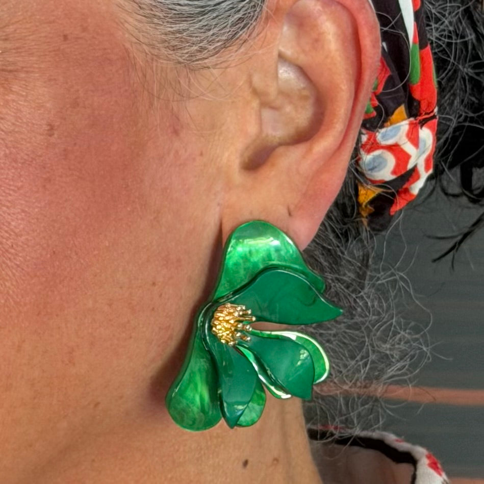 Close-up of a person wearing a green floral earring.