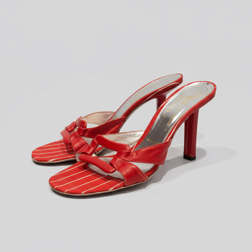 Red high-heeled shoes on a wooden surface with a white background