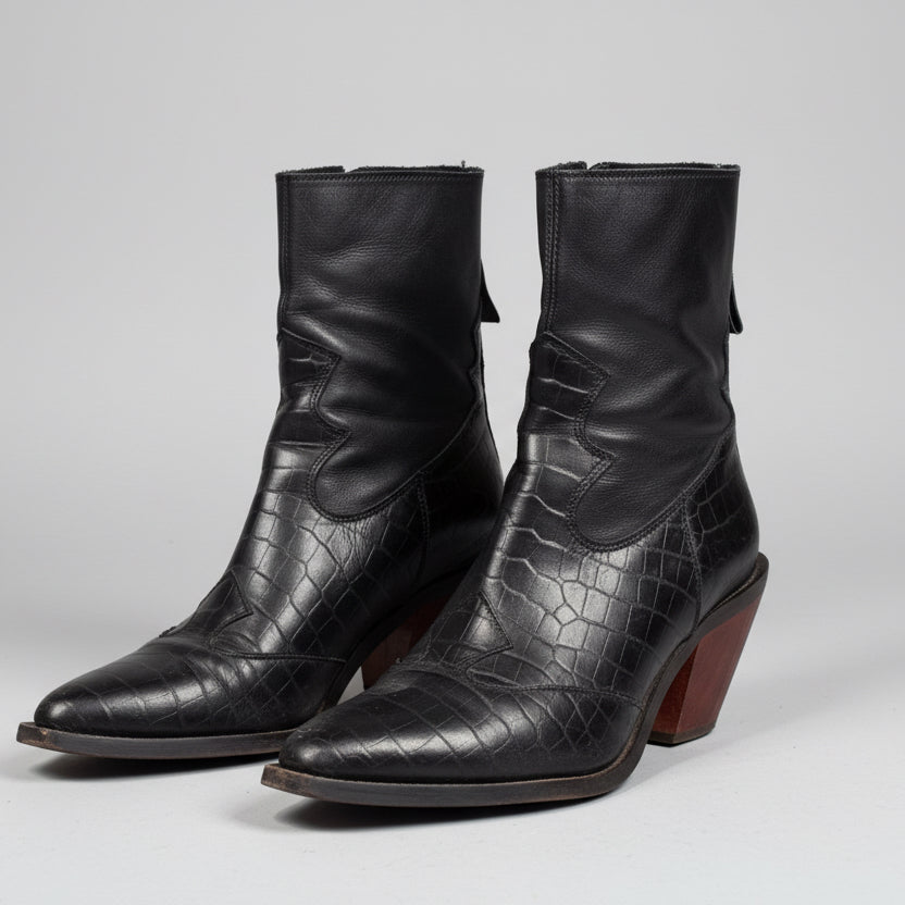 Pair of black leather boots with a textured pattern on a light gray background