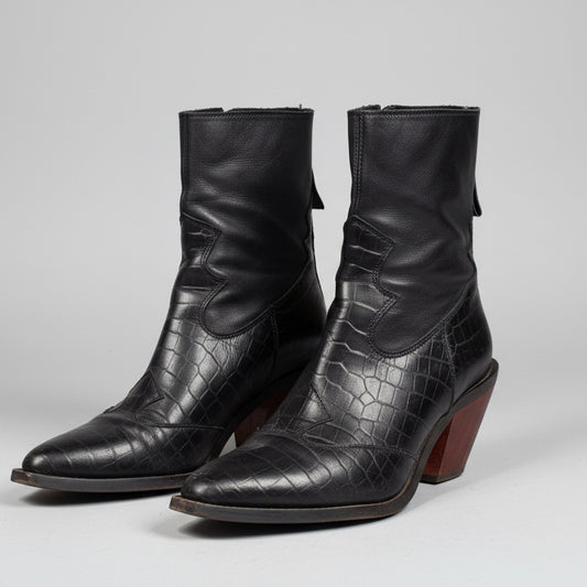 Pair of black leather boots with a textured pattern on a light gray background