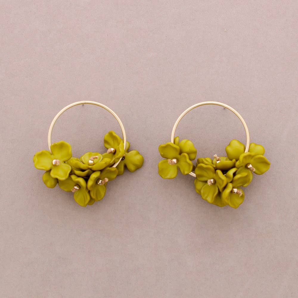 Pair of green floral hoop earrings on a beige background