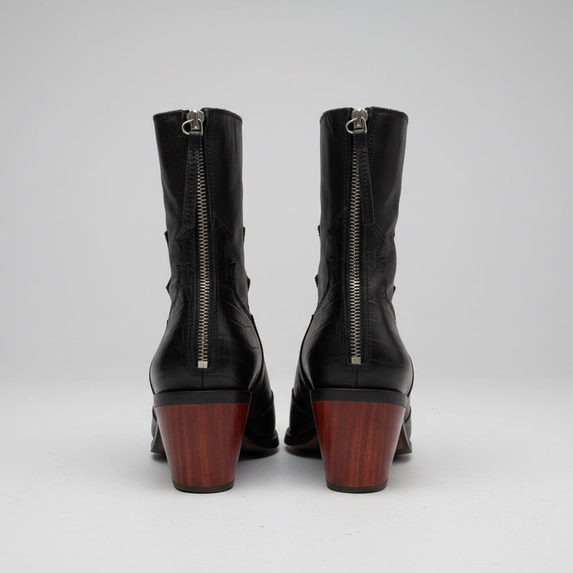 Pair of black boots with wooden soles on a wooden surface