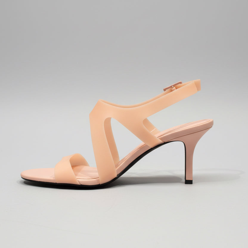 Beige high-heeled sandal on a wooden surface with a neutral background